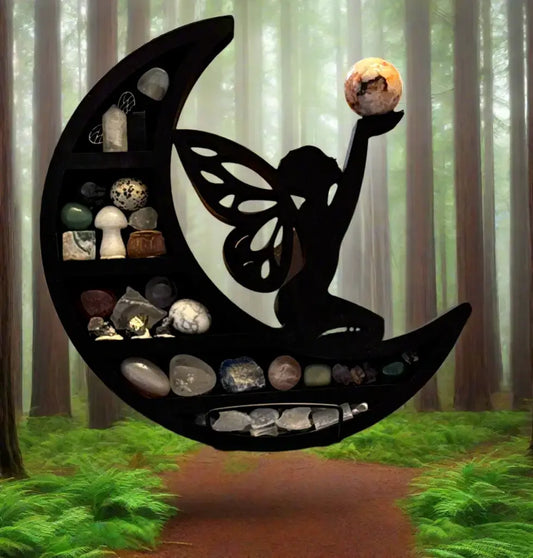 A black crescent moon shelf with a fairy silhouette, shown floating in a misty forest. The shelf is filled with various polished stones, crystals, and small decorative objects.