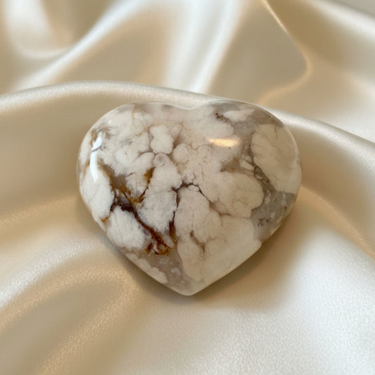 shimmering flower agate carved heart on a silk fabric 