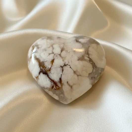shimmering flower agate carved heart on a silk fabric 