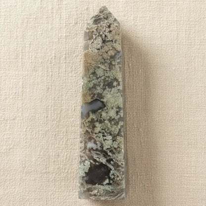A carved pointed flower agate tower showing possible manganese inclusions, light green mossy and dark green colors