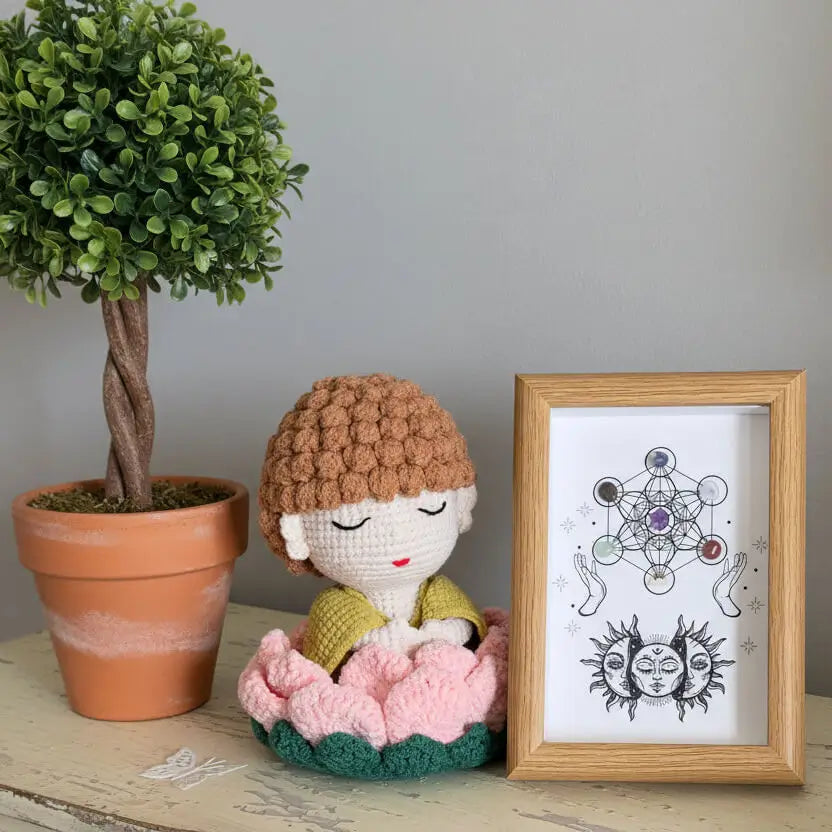 Crocheted buddha doll on a lotus flower with a chakra grid shadow box. Genuine Chakra crystals included in the grid 
