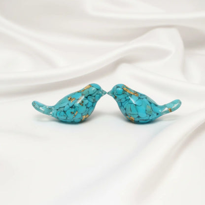 close up of two orgonite birds showing turquoise and metal shavings encased in resin  