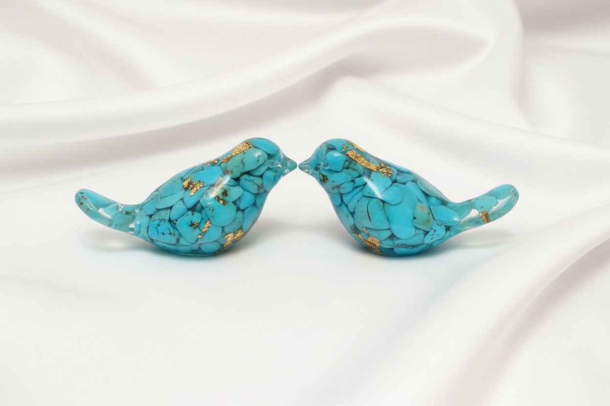 close up of two orgonite birds showing turquoise and metal shavings encased in resin  