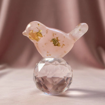 close up of rose quartz orgonite bird with rose quartz crystals and metal shavings encased in resin 
