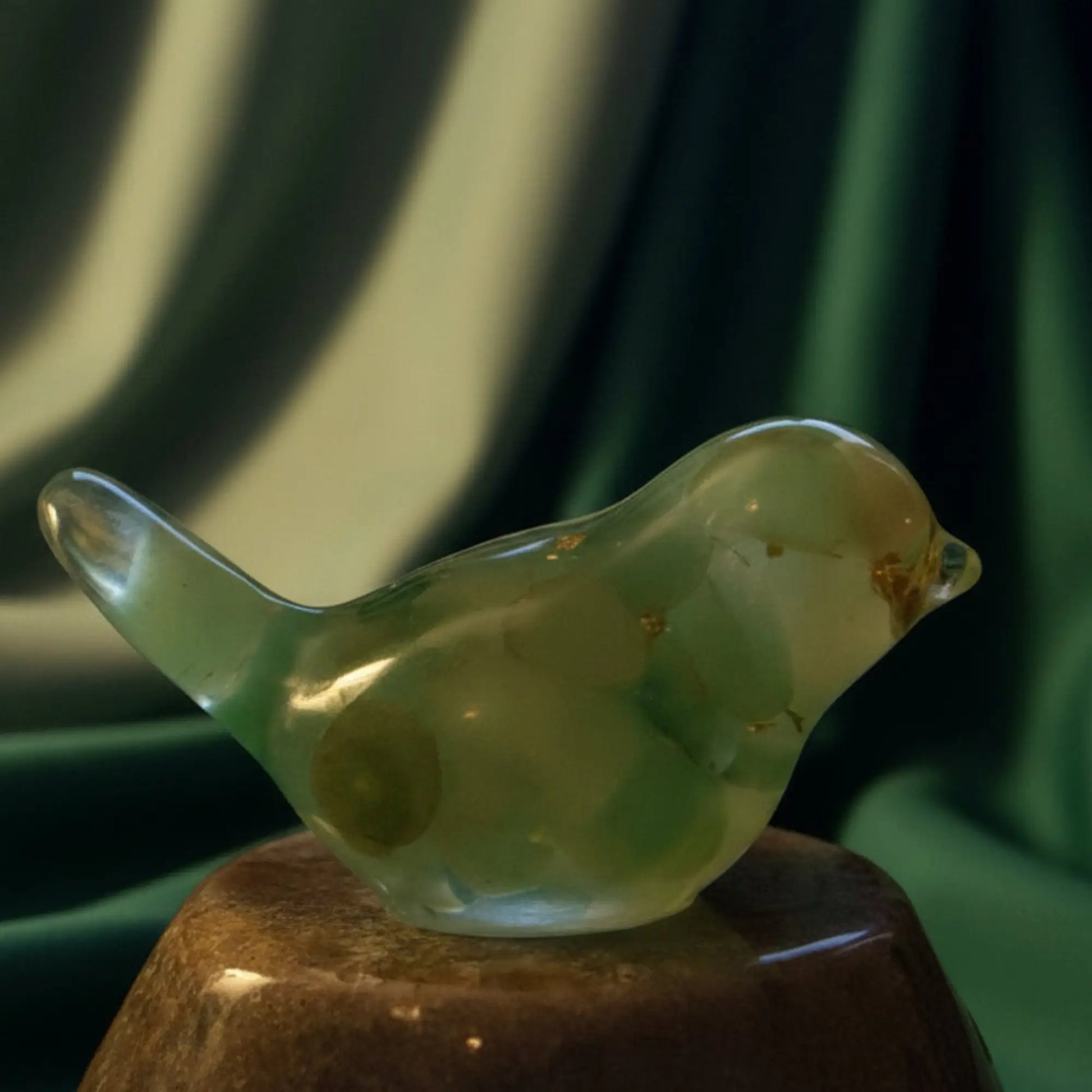 close up of green chalcedony orgonite bird with crystals and metal shavings 