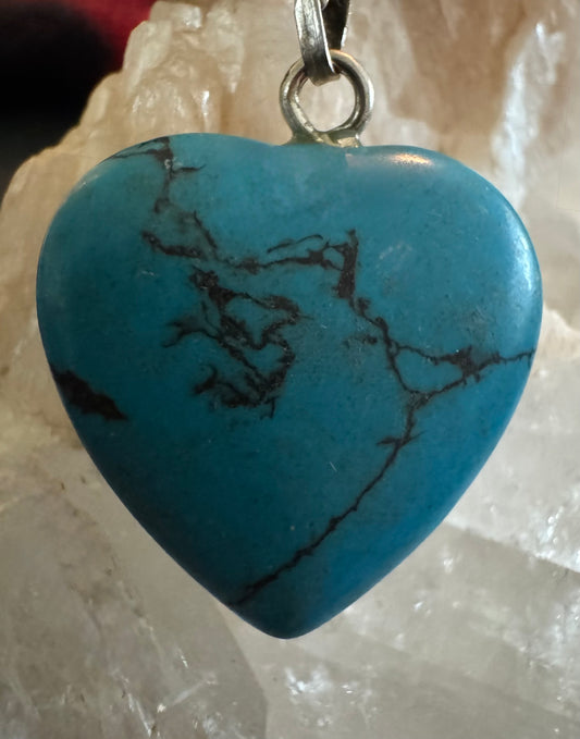 Turquoise heart pendant with dark veining, silver ring.

