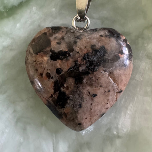 Heart-shaped rhodochrosite pendant with silver bail.

