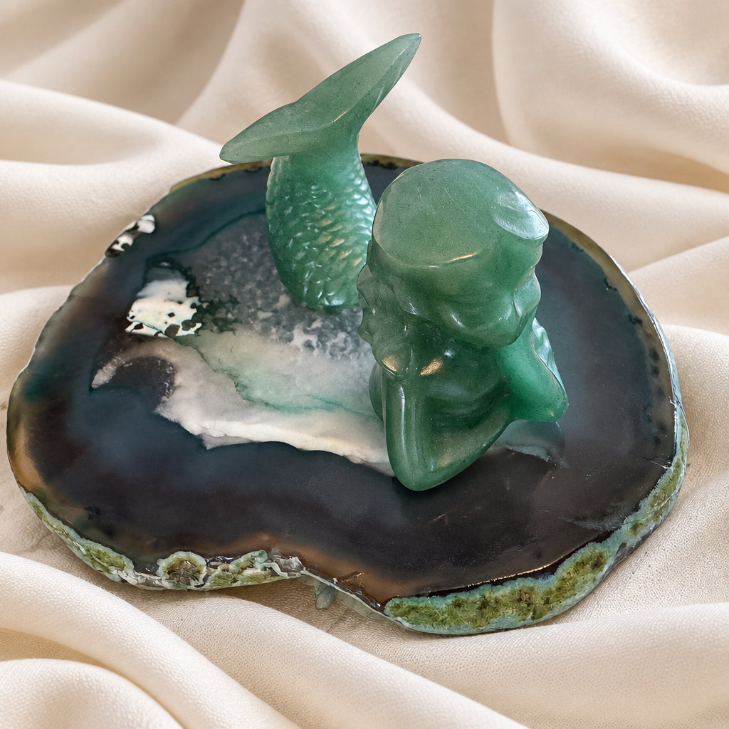 green aventurine mermaid figurine on a quartz slab
