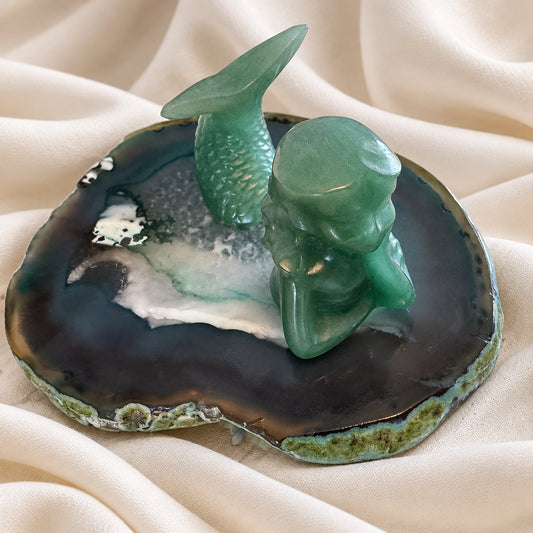 green aventurine mermaid figurine on a quartz slab
