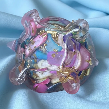 close up of mini resin carnival colors dyed agate filled. close up of belly showing metal shavings and dyed agate chips