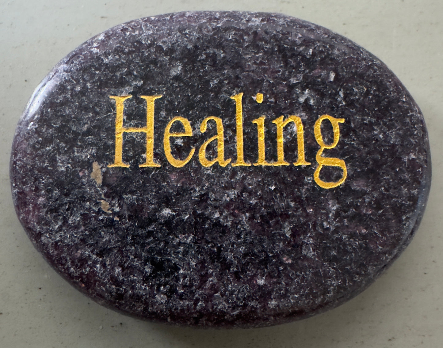 Oval stone with the word "Healing" in gold.
