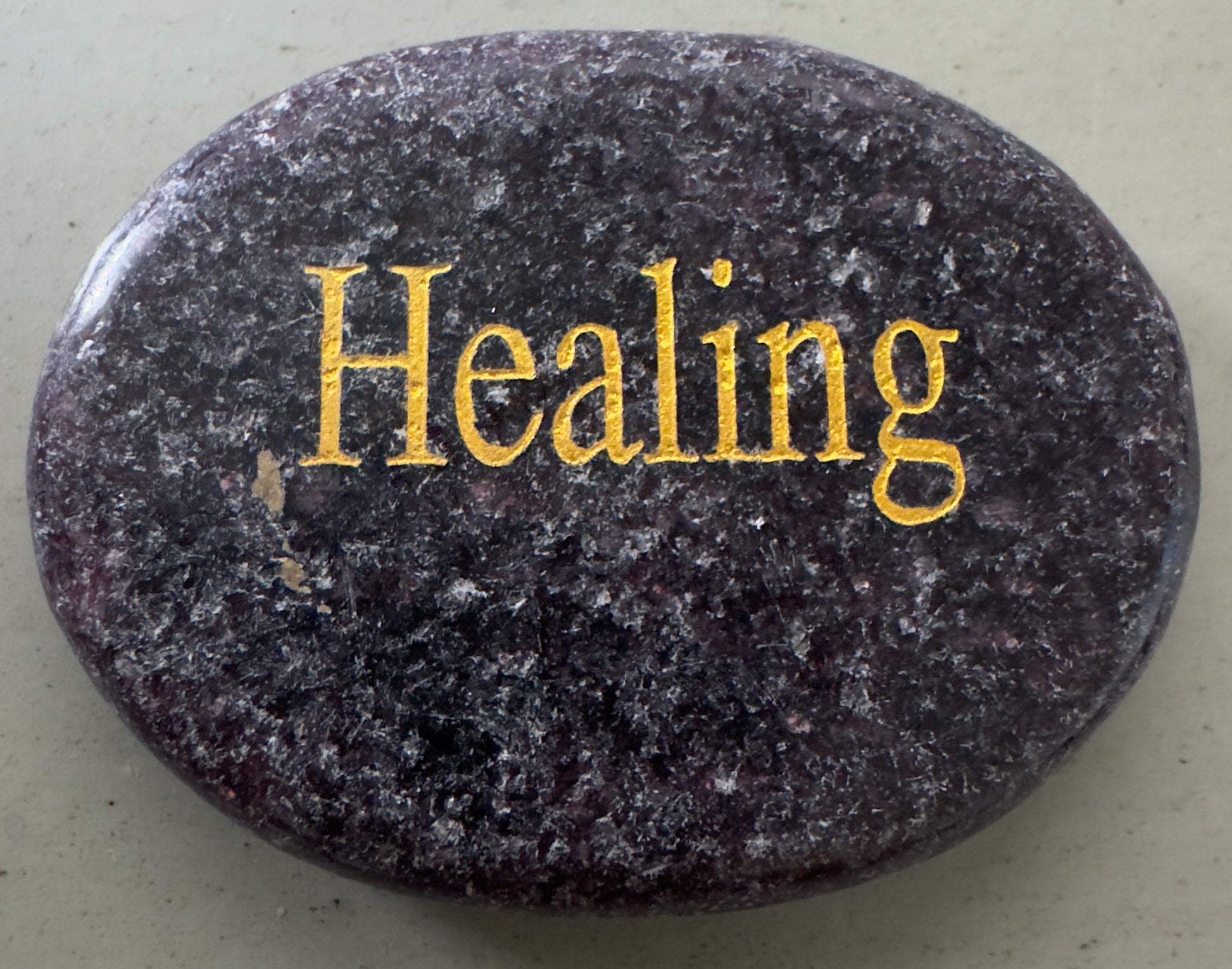 Oval stone with the word "Healing" in gold.
