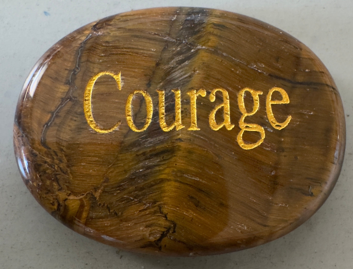 Brown stone with "Courage" in gold.