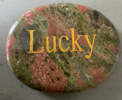 Polished unakite stone with "Lucky" inscription.
