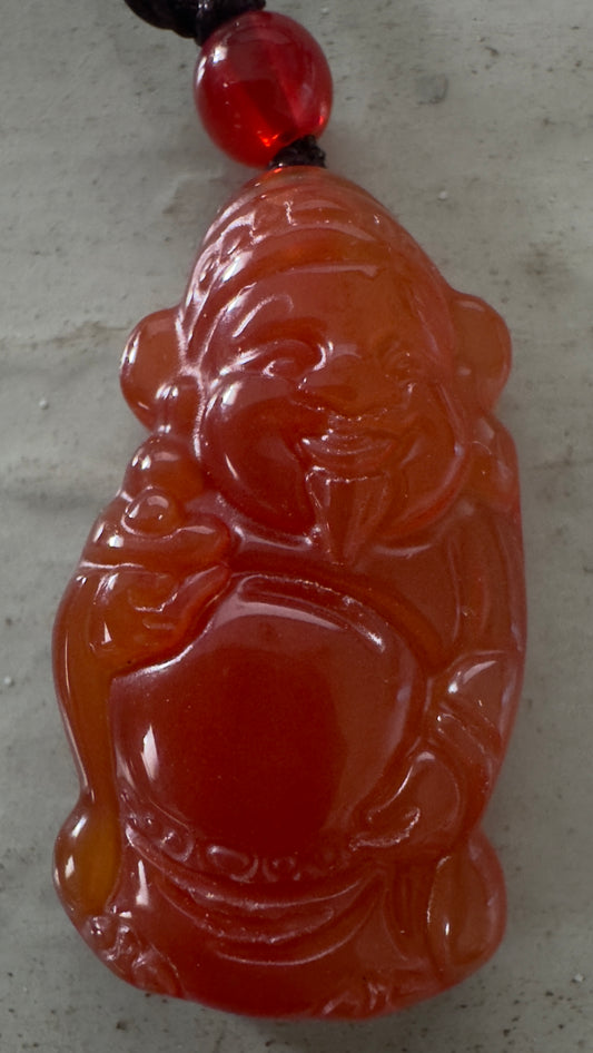 Orange Buddha pendant with red bead.
