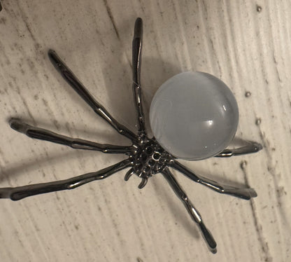 Metal spider figurine with translucent orb body.
