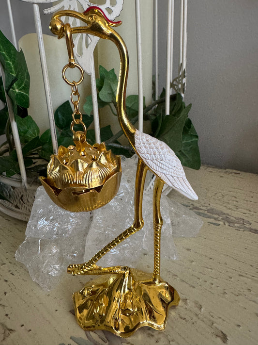 Golden crane incense holder with white wings, standing on a lotus flower base with ice crystals.