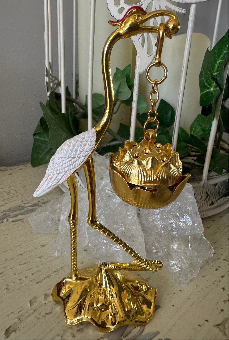Golden crane incense holder with white wings, standing on a lotus flower base with ice crystals.