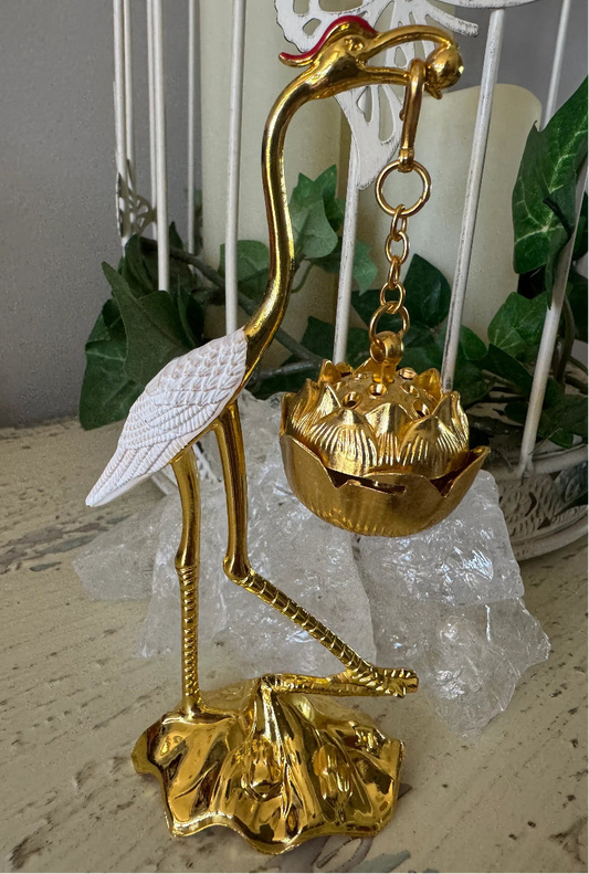 Golden crane incense holder with white wings, standing on a lotus flower base with ice crystals.