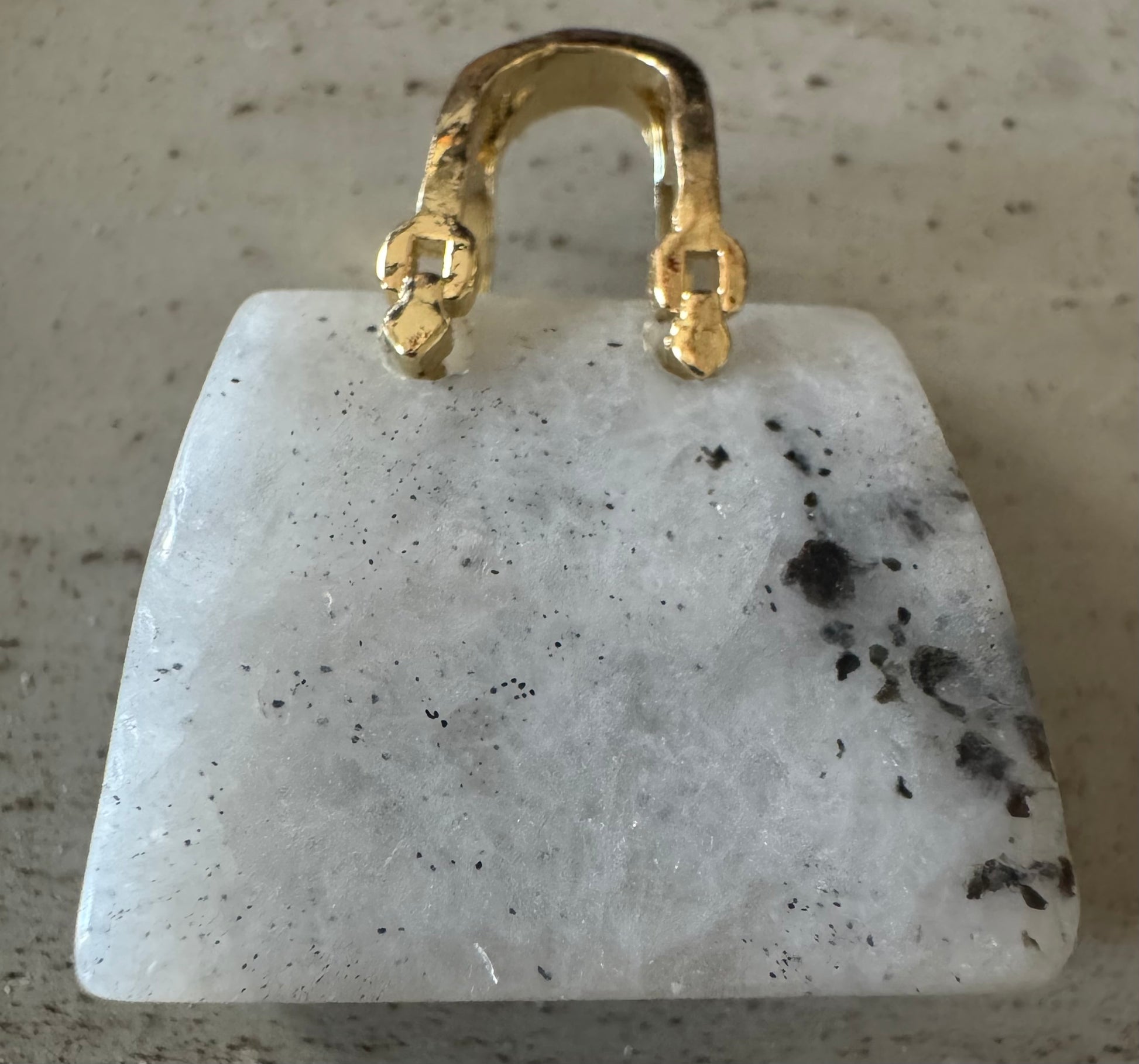 White gemstone pendant with gold bail.
