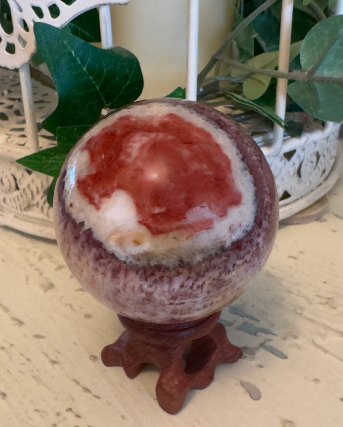 Rhodochrosite sphere on display stand
