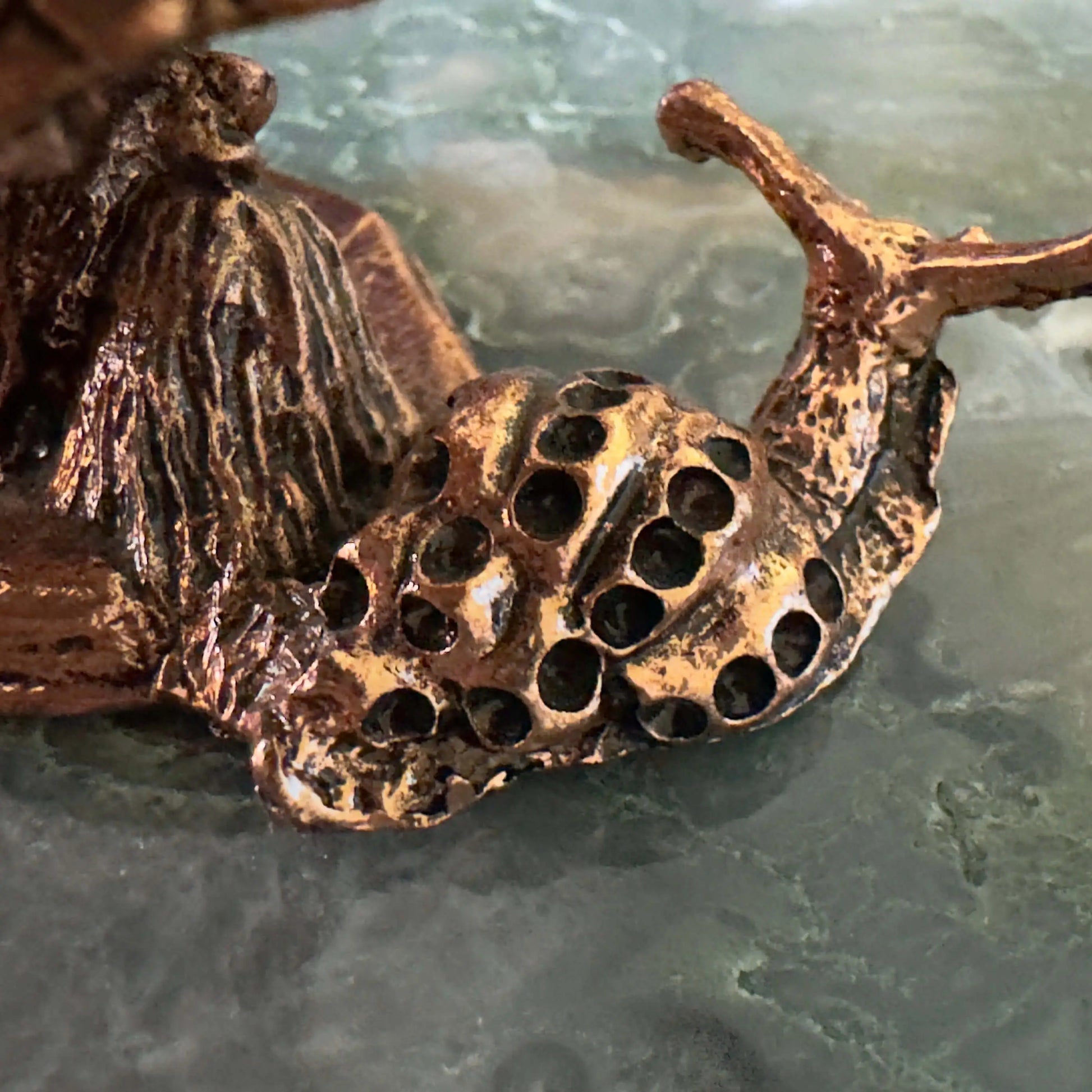 Close-up of a bronze snail figurine.