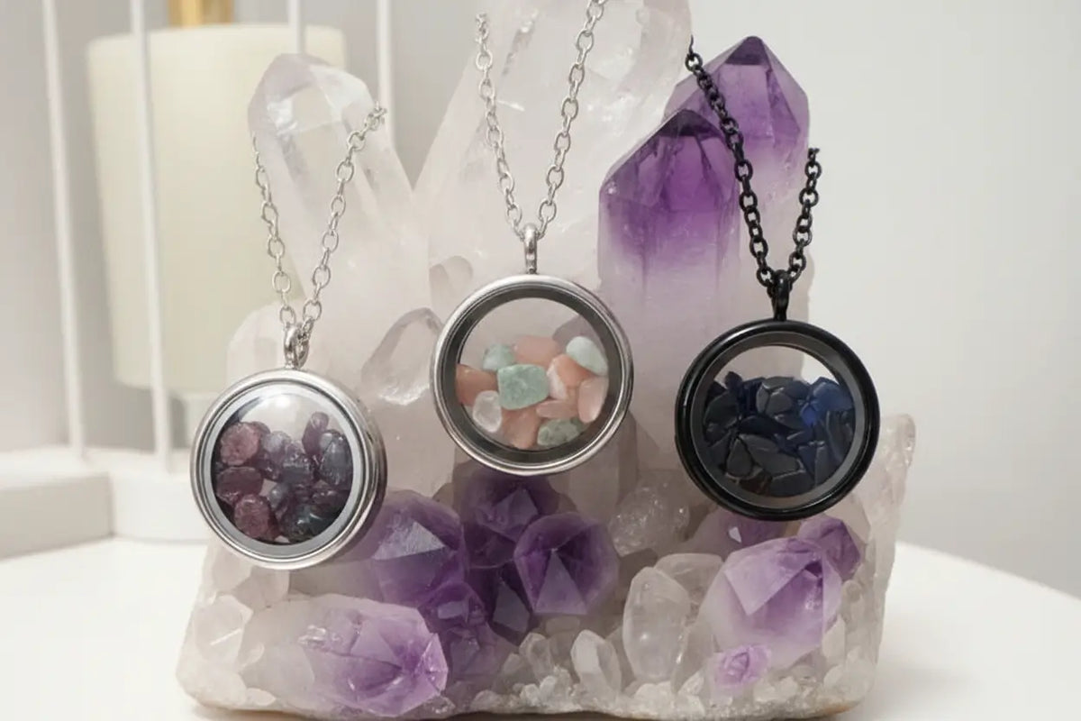 Three gemstone necklaces on a marble slab supported by a black metal stand.