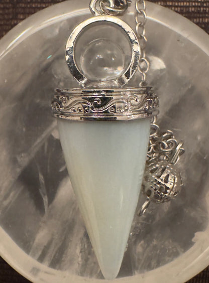 Light green cone-shaped crystal pendulum close-up