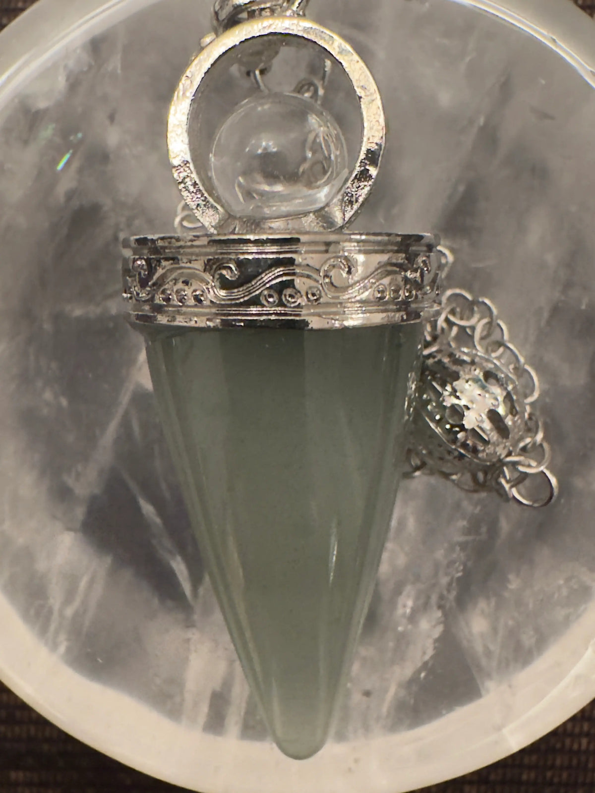 Green pendulum crystal with silver setting and chain.