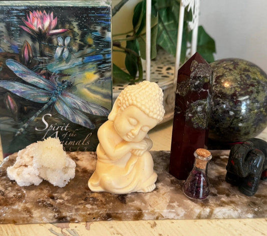 Decorative setup with a small Buddha statue, Dragons Blood crystals, Oracle Cards and Agate Slab 