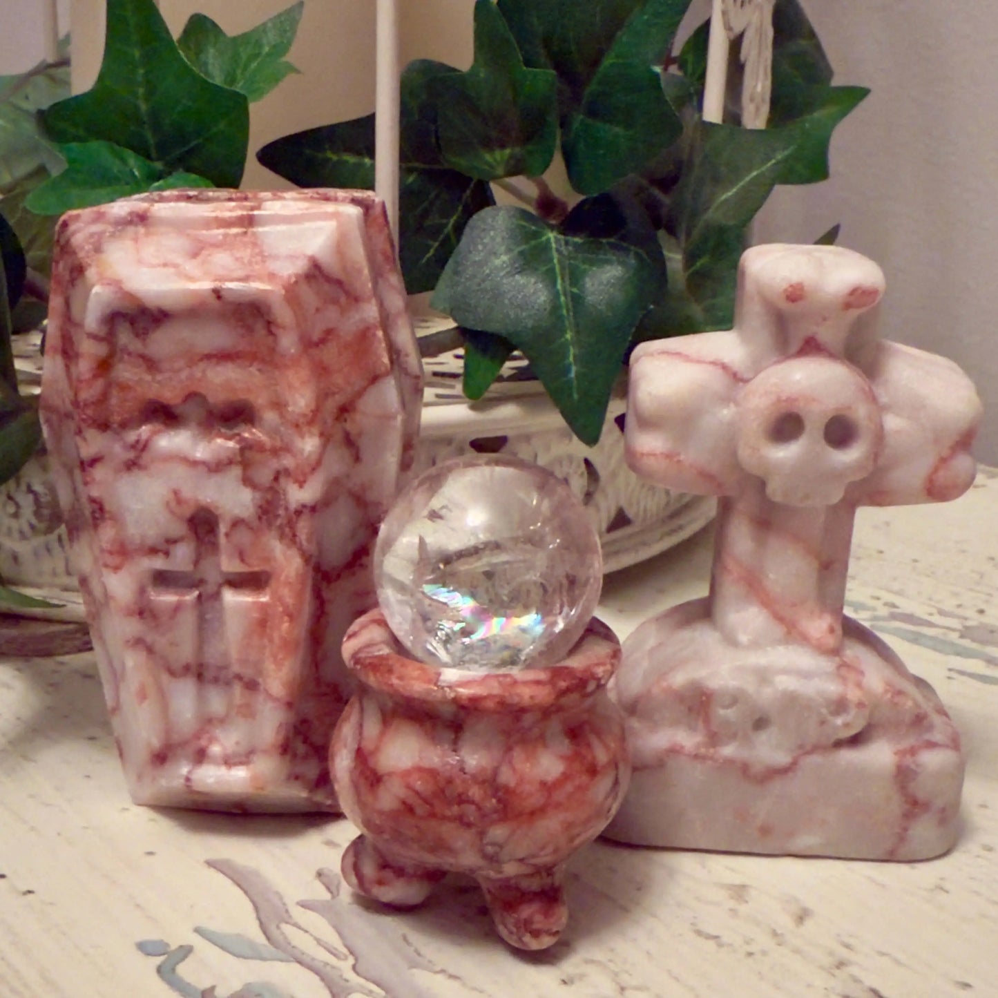 Coffin, cauldron with crystal ball, and skull cross statuettes.