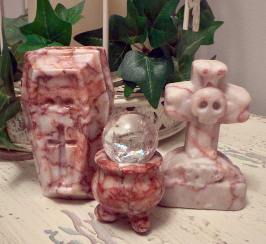 Coffin, cauldron with crystal ball, and skull cross statuettes.