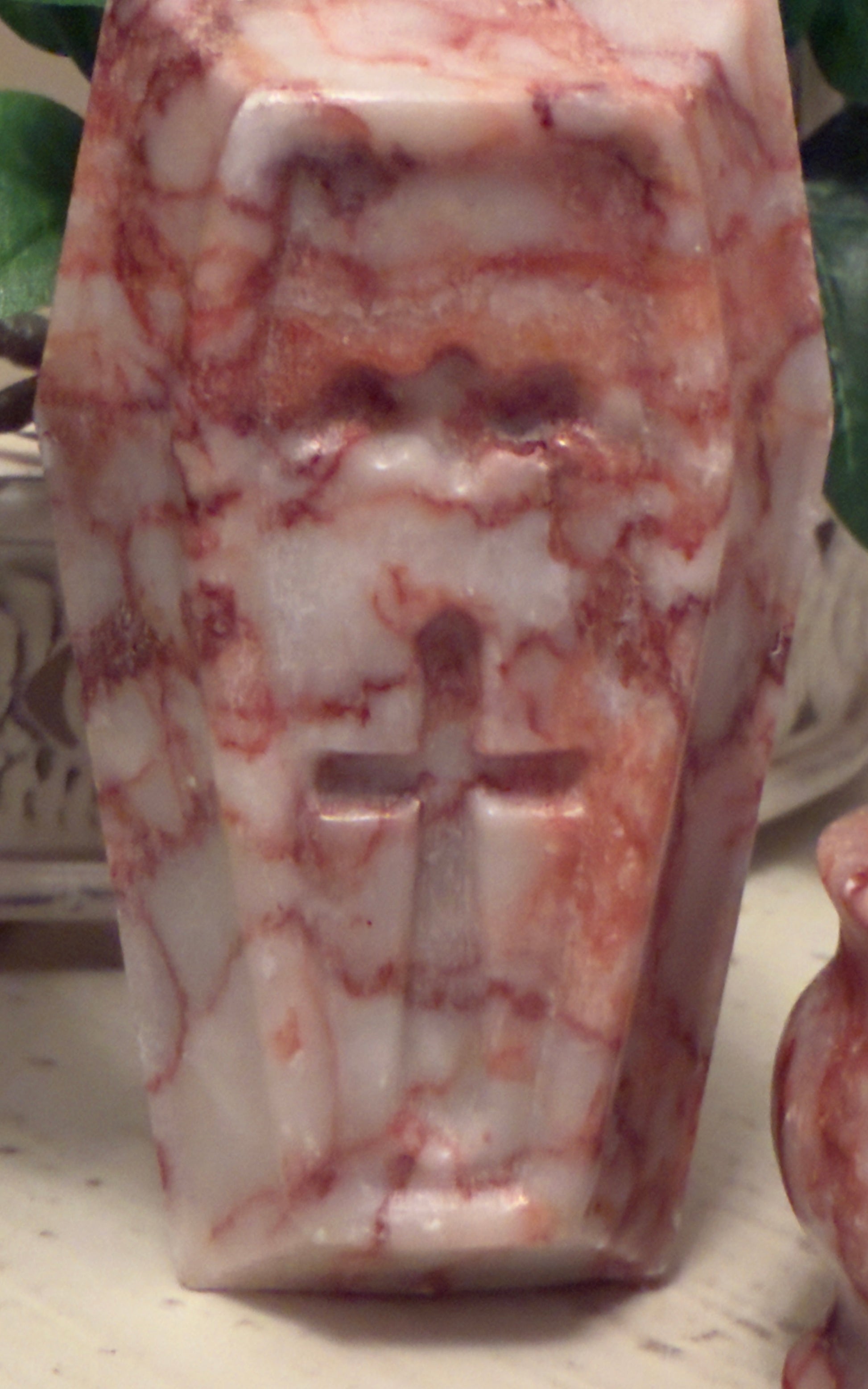 Red and white marbled stone carving of a cross.