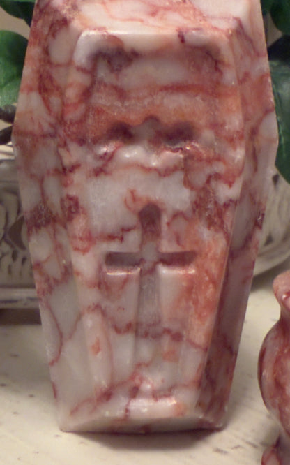 Red and white marbled stone carving of a cross.