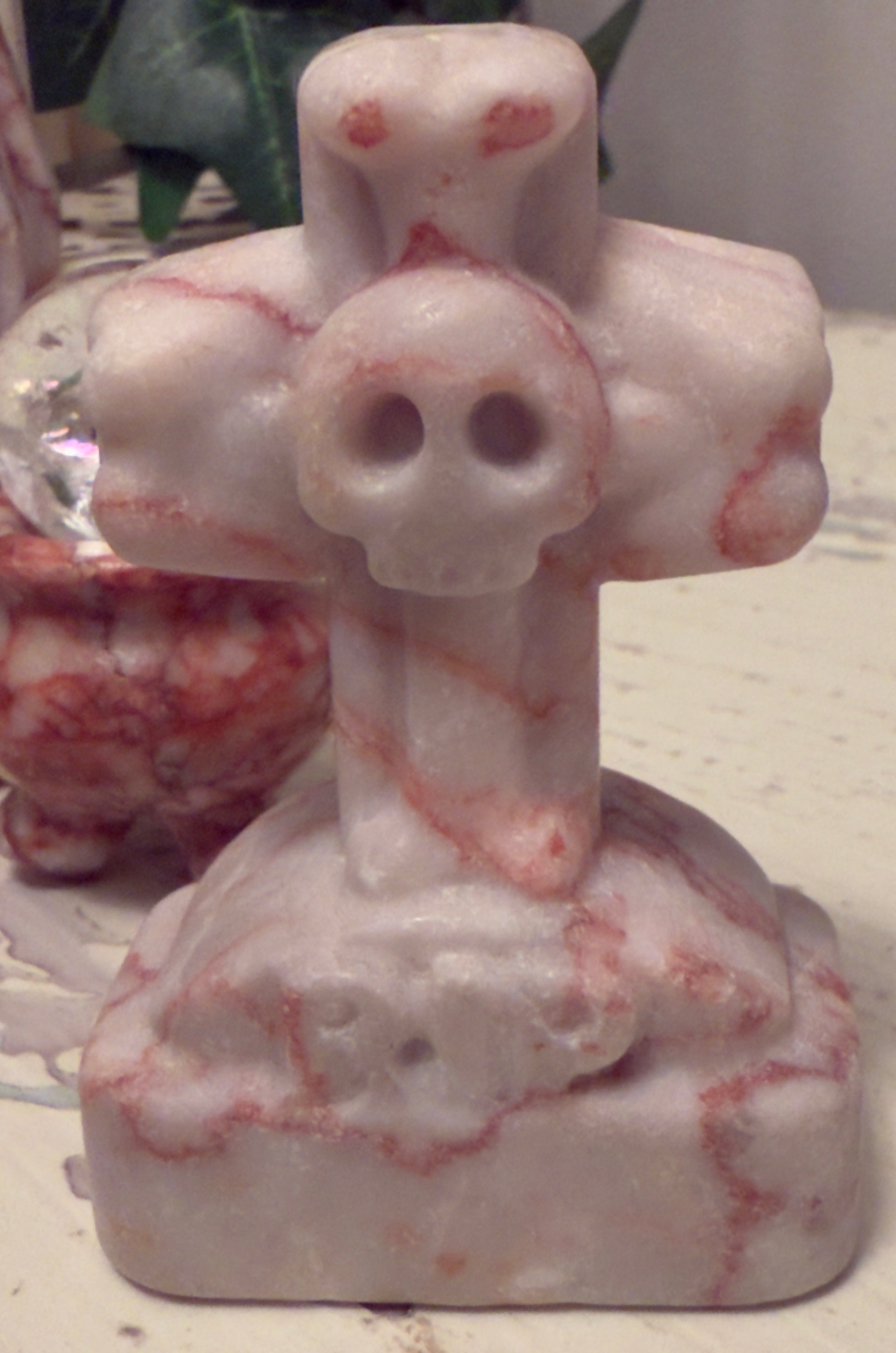 Marble sculpture of cross with skull.