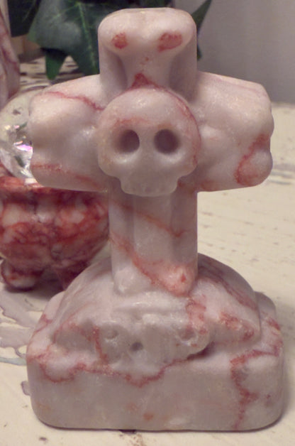 Marble sculpture of cross with skull.