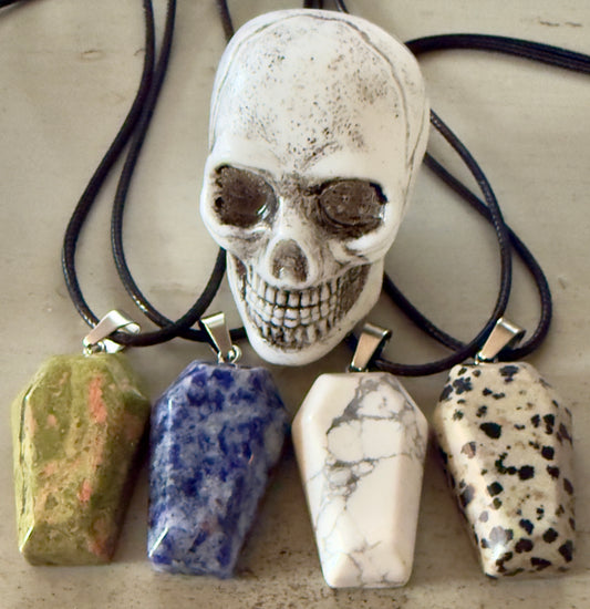 Skull and four coffin-shaped stone pendant necklaces.
