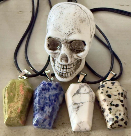Skull and four coffin-shaped stone pendant necklaces.

