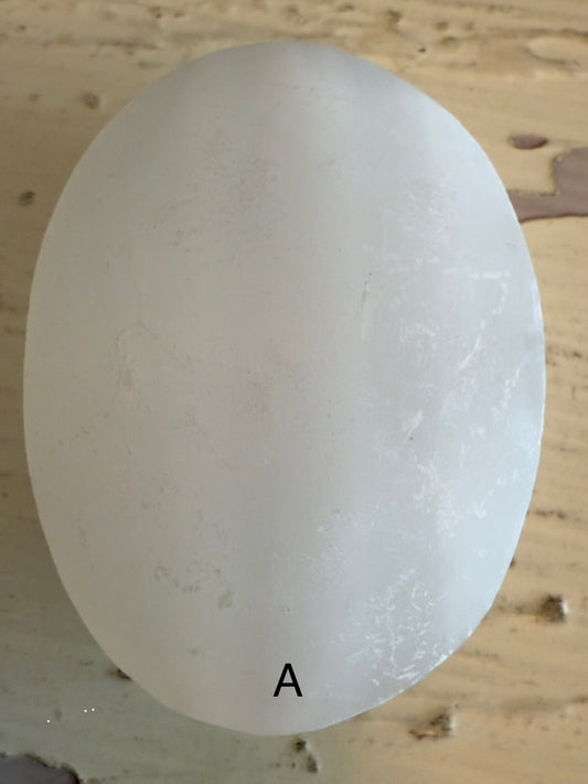 Off-white, oval-shaped object with 'A' on it.