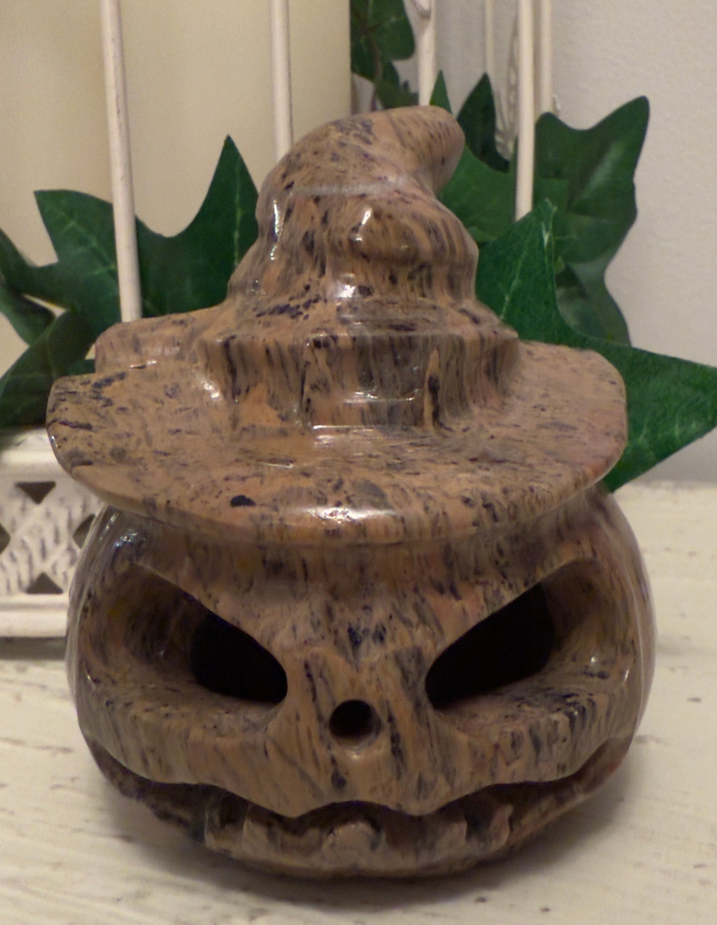 Carved stone Halloween pumpkin with witch hat.