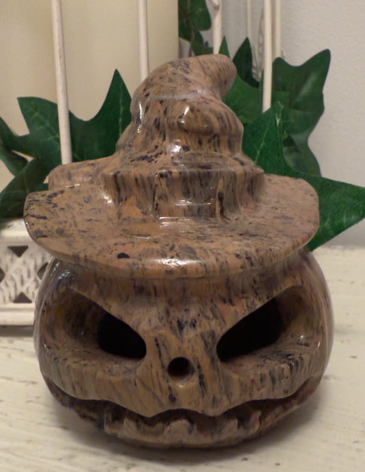 Carved stone Halloween pumpkin with witch hat.