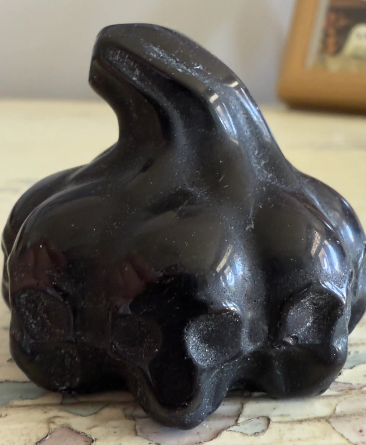 Shiny black, abstract, sculptured stone object.
