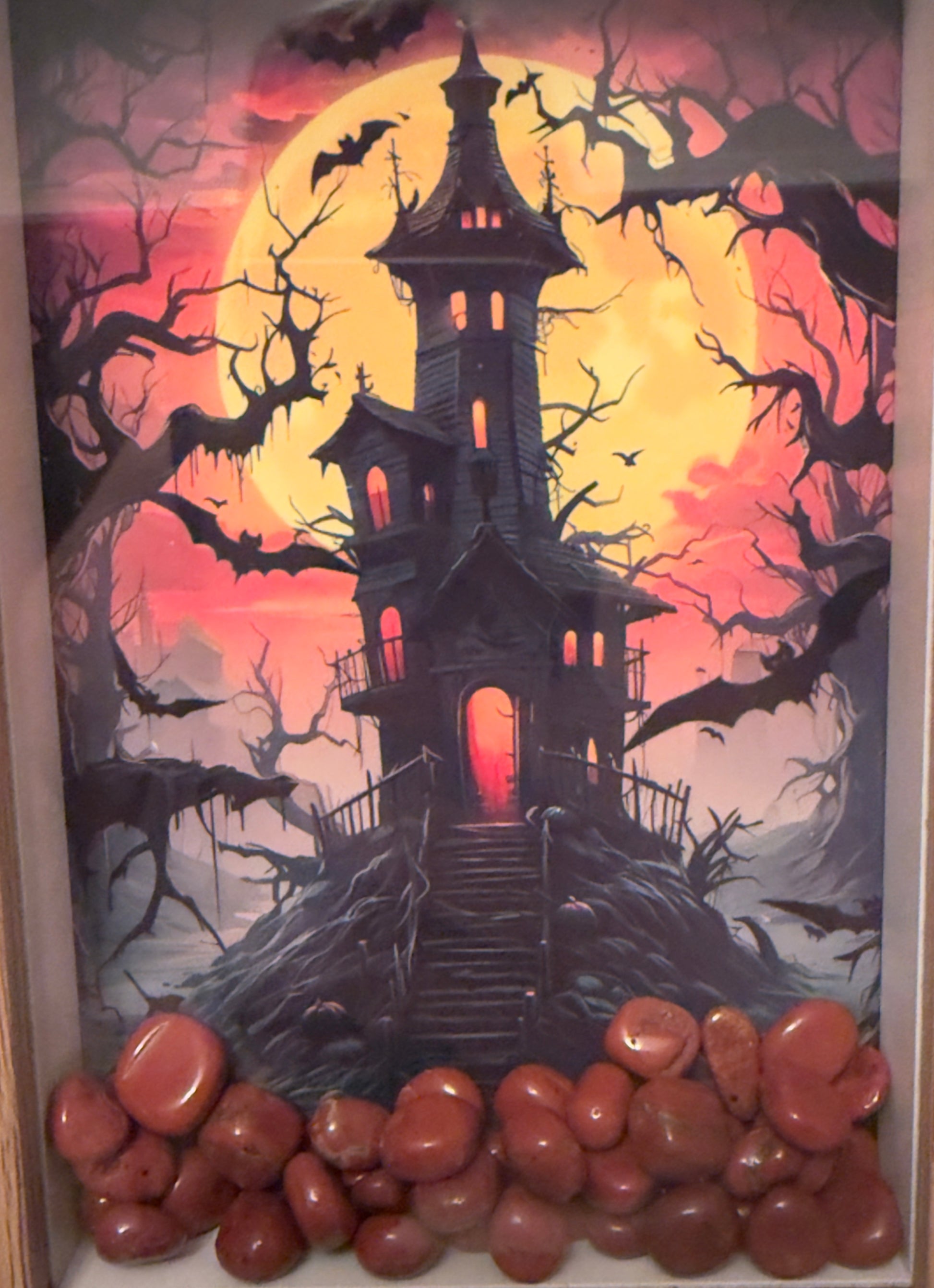 Framed Halloween haunted house artwork with red stones.