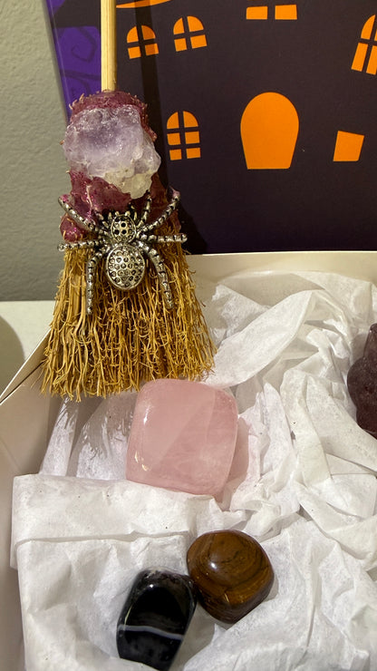 close up of actual pieces in the bundle, broom with amethyst and spider charm, rose quartz cube and assorted tumbles 