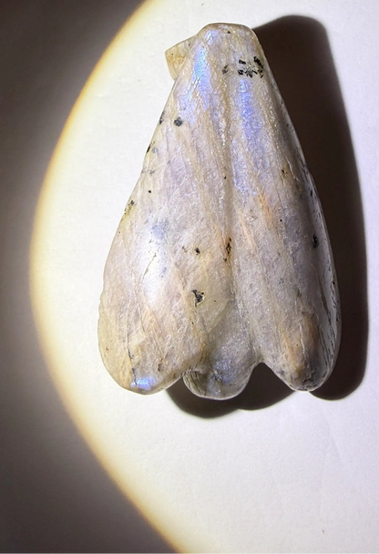 photo of the back rainbow moonstone carved angel figurine with soft blue adularescence