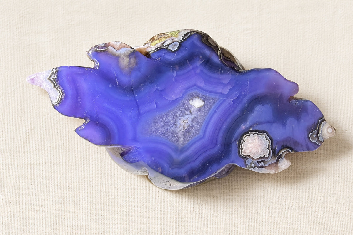 photo is close up bottom of blue flower agate carving.  center is filled with clear quartz and stone has white flower patterns