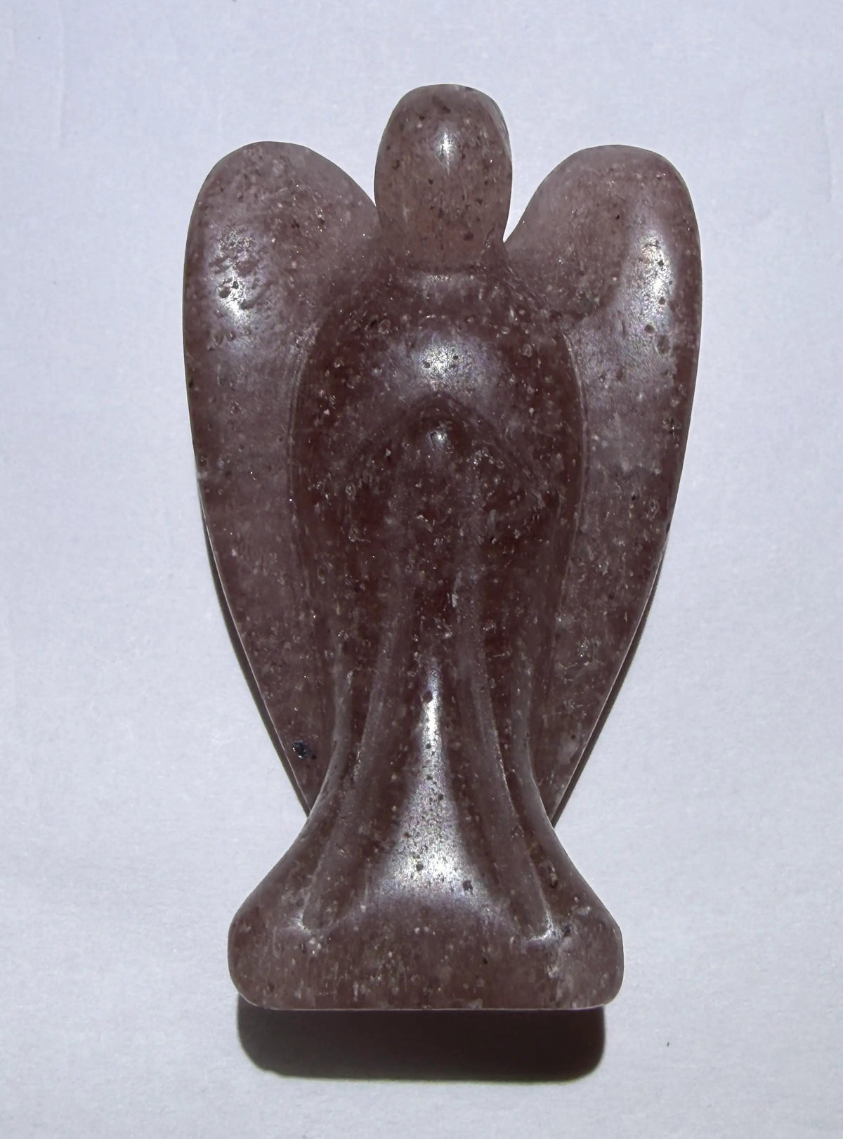Strawberry Quartz hand carved angel with wings - crystal rests on a white background