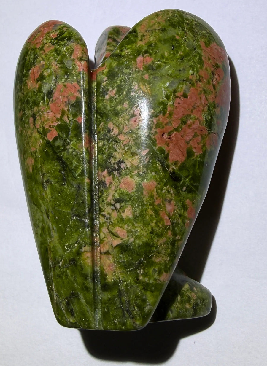 photo of the back unakite mineral hand carved angel resting on a white background
