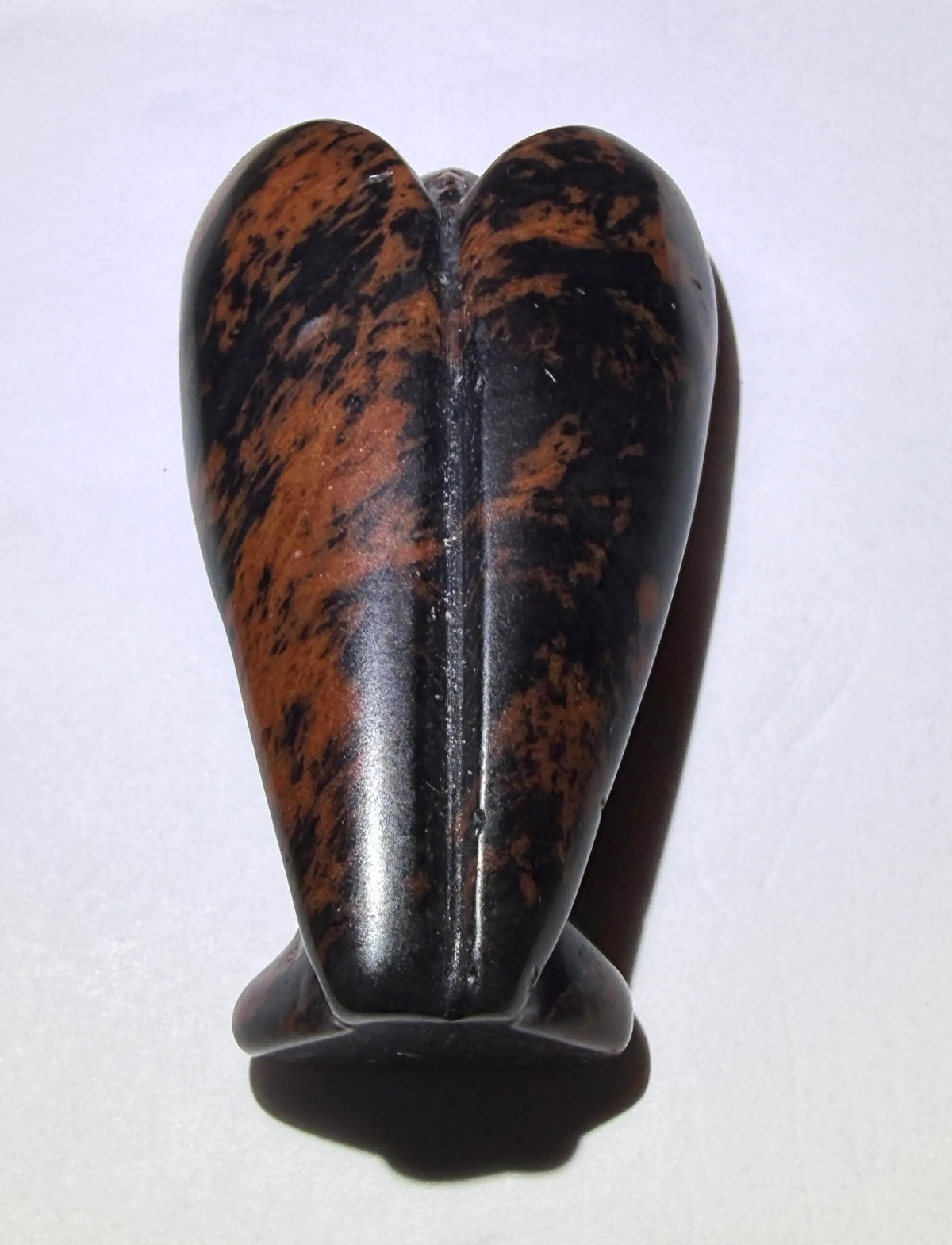 photograph of back side of angel carved in mahogany obsidian stone 