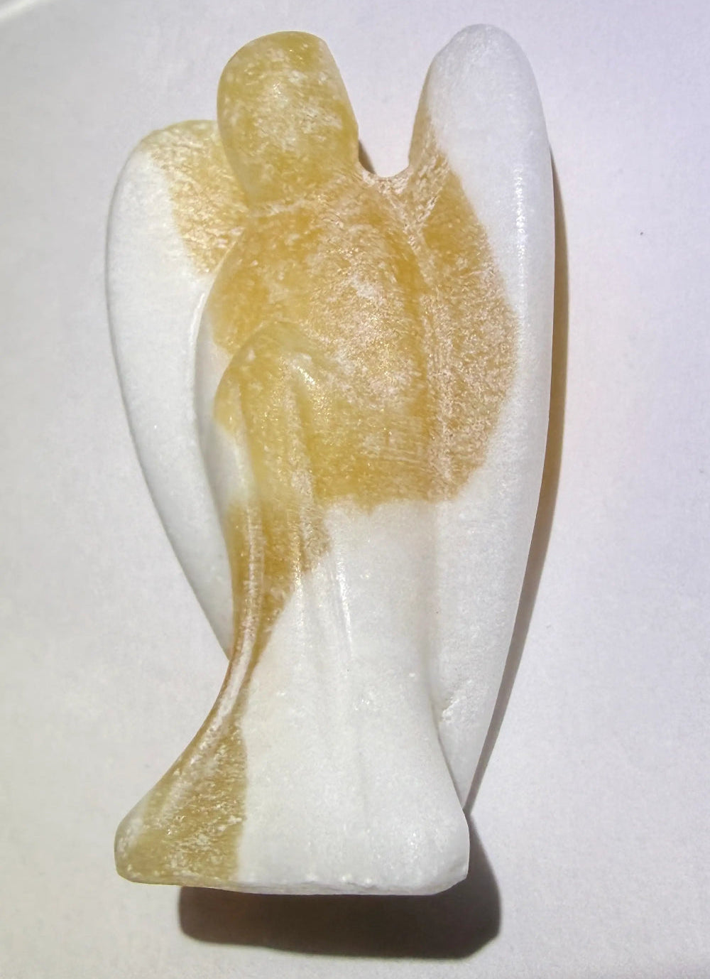 A carved angel figurine - close up side view. Orange calcite 